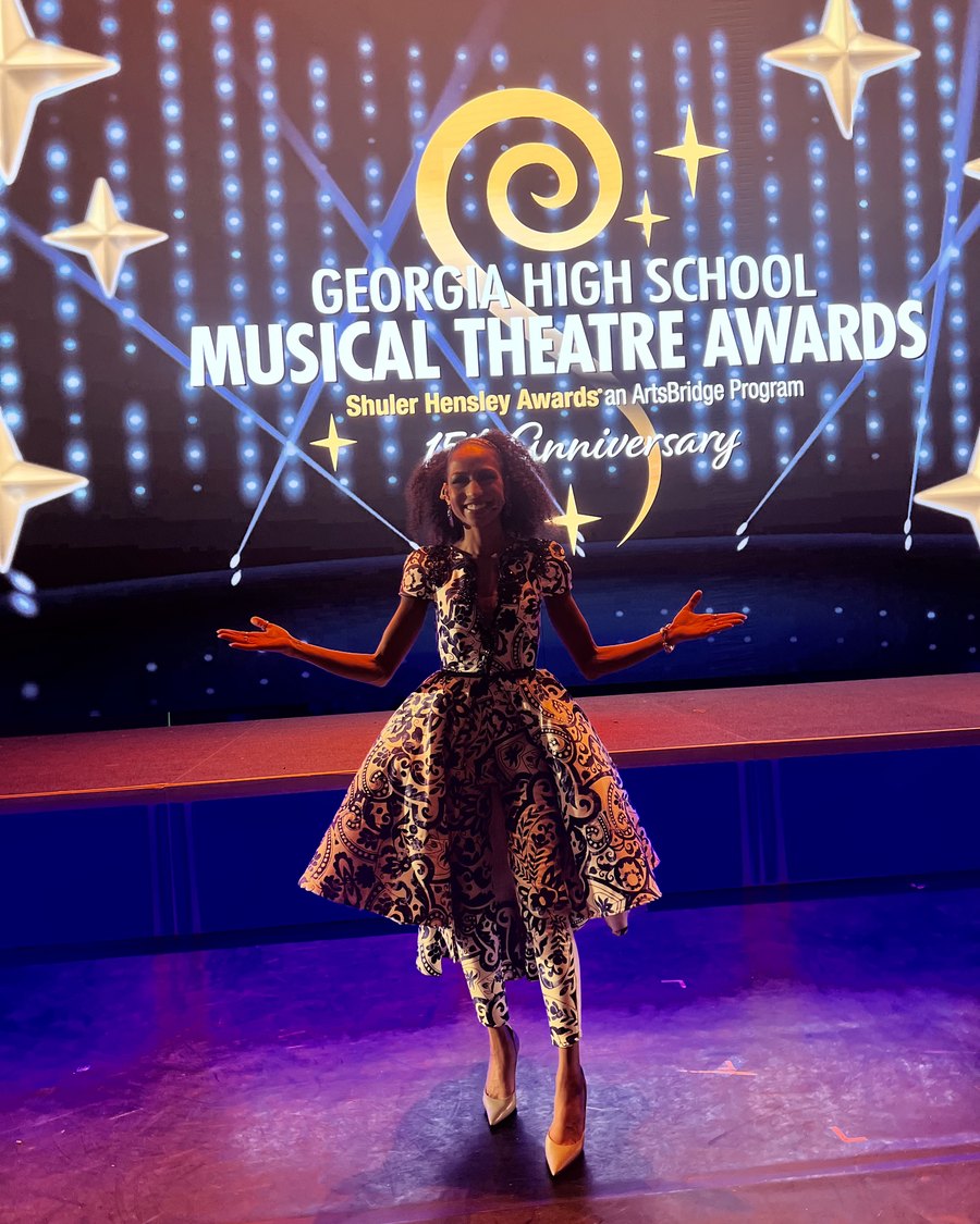 Chelsea on stage beneath the Georgia High School Musical Theater Awards sign